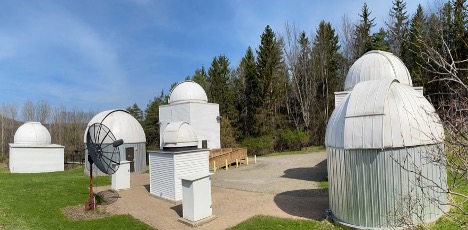 The image shows several white buildings with round domes.